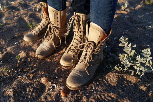 Woman And Man In Army Beige Boots Spend Outdoor Activities In The Wilderness