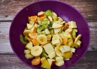 Fruit salad in a bowl on wooden background