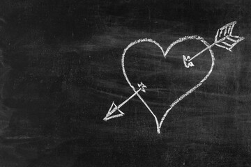 Heart symbol with arrow on chalk board, love symbol. Copy space