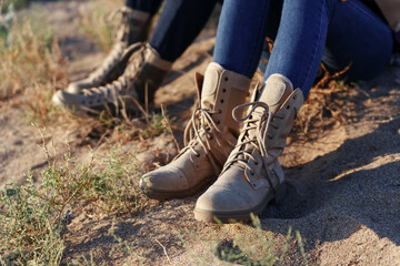 Male and female legs in army beige boots and jeans. Outdoor activities couples in the wilderness