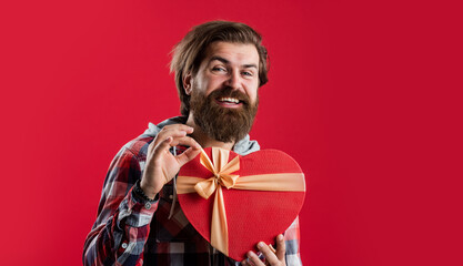 bearded male hipster in checkered shirt hold heart box gift, love