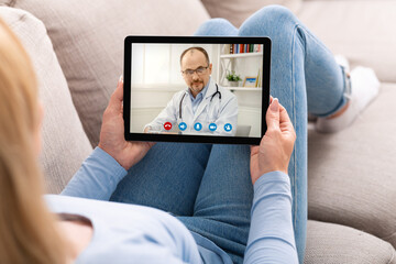 Woman Video Conferencing With Male Doctor On Digital Tablet At Home