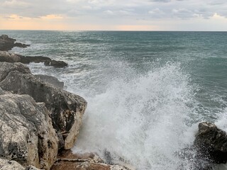 Splashing sea water at the sea rocky coastline