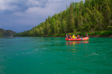 Tourists sail in a boat along a mountain river.
