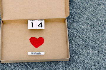 Happy Valentines Day, love delivery, cardboard box with heart symbol and 14 February date , gray textile background, valentine at home