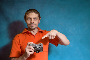 a European man with a film camera in his hands. Photographer with an analog camera and photographic film.