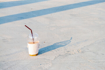 Plastic coffee mugs placed on a concrete floor, littering.
