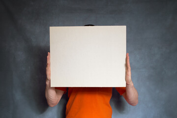 A man holds a blank ad in his hands. Copy space.