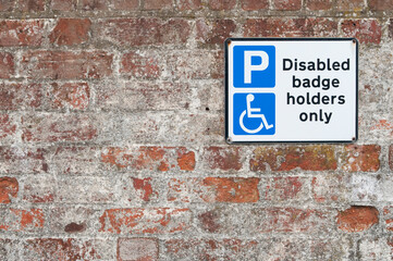 Fototapeta na wymiar Disabled parking space plate on brick wall