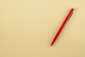 Red pen on an isolated yellow background.