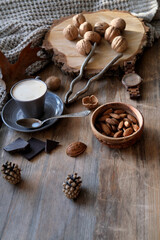 Fototapeta na wymiar cup of coffee, different kinds of nuts, walnut, hazelnuts, almonds on old wooden table boards, edible seed kernels, food concept, confectionery ingredient