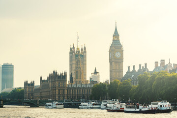 The Palace of Westminster and the Clock Tower with boats on the River Thames in London, England, UK