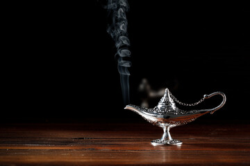 A magic lamp that makes dreams come true on a wooden table on an enchanting night 