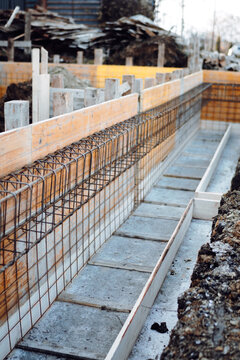 Construction site details - house building. Reinforced steel bars in wooden casing, on concrete foundation © aboutmomentsimages