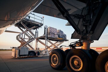 Loading of cargo containers to plane at airport. Ground handling preparing freight airplane before...