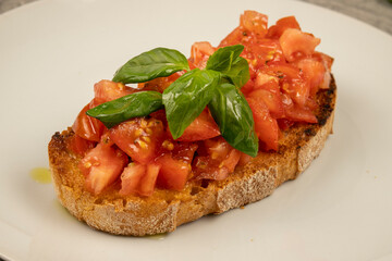 Bruschetta (toasted bread) with tomato and basil in closeup. Classic Italian appetizer.