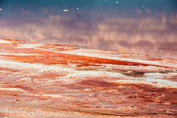 Closeup of salt layers on the shores of a pink salt lake.