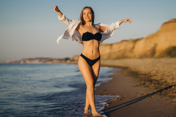 Naklejka premium Pretty brunette woman relaxing on the beach at the sea.