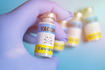 Danger, fear of vaccination coronavirus concept. Vaccine label with warning of toxicity in a gloved...