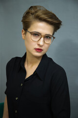 Portrait of a young girl with dark hair and glasses, close-up