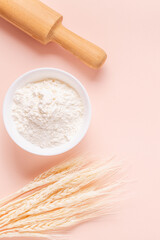 Ingredients for baking on light pink background.