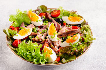 salad Nicoise with tuna, eggs, green beans, tomatoes,  olives, lettuce and anchovies