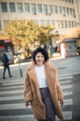 Fototapeta premium Happy smiling woman walking on street, and looking at camera.