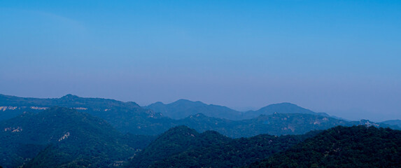 Fototapeta na wymiar Spectacular blue and cyan mountain range view under blue sky during daytime.