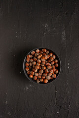 Obraz na płótnie Canvas Hazelnuts on a bowl isolated on black background.