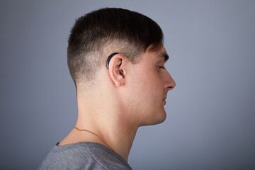Naklejka premium A young man is wearing a hearing aid. ENT equipment concept 
