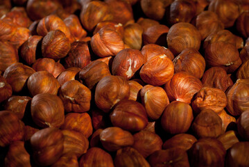 Peeled hazelnuts close up. Texture of nuts. Lots of nuts in a pile. Contrasting dramatic light as an artistic effect.