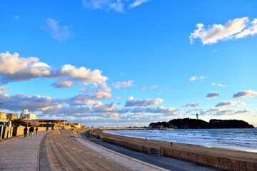 Fototapeta na wymiar 白い雲が引き潮の海に映り込む江ノ島の海岸