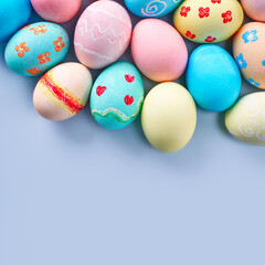 Fototapeta na wymiar Colorful Easter decorated eggs on bright blue table background.