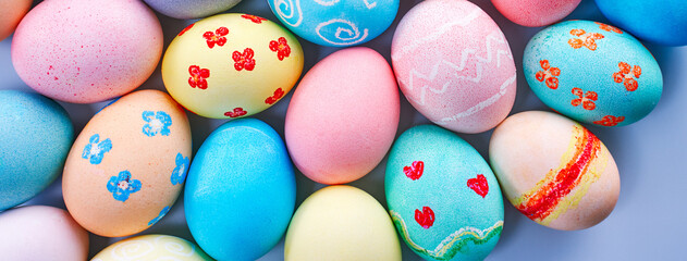 Colorful Easter decorated eggs on bright blue table background.