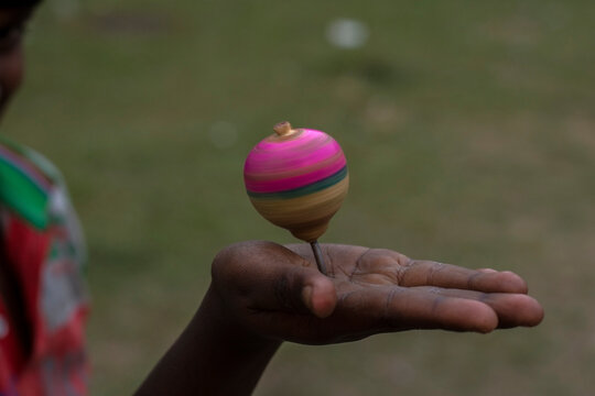 A spinning top or Lattu in Hindi spinning on a hand.