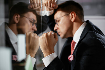 Exhausted businessman in conference room use sticky notes on glass wall. Tired businessman making a business plan.
