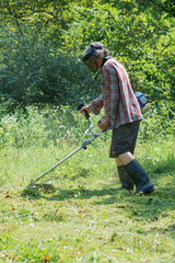 Senior man mowing green grass