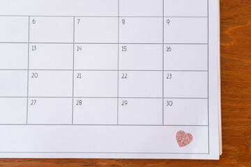 Top view of a calendar with a heart in a corner.