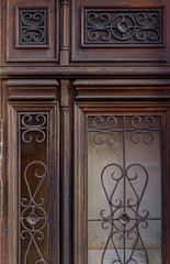 Old brown wooden door with rustic forged wrought iron ornaments