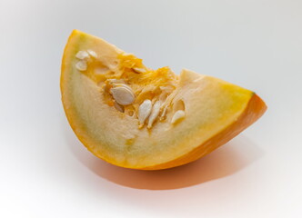 A piece of pumpkin close-up on a white background. Focus in the center
