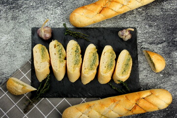 Home made Sliced garlic bread on a black stone plate. Dark background