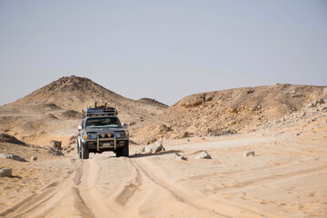 truck in the desert of bahariya national park egypt. Offroad exploring extreme environment. Car tracks and stone hills. Adventure scene, sahara safari. Extreme travel destinations. - obrazy, fototapety, plakaty
