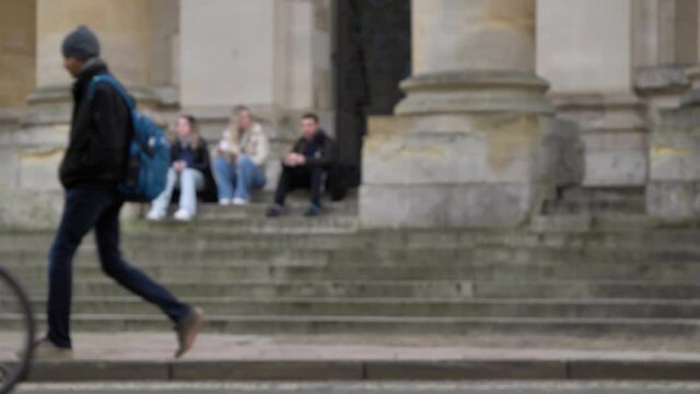 Defocused Wide Shot of People Sitting On Steps of Clarendon Building as Pedestrians Walk Past
