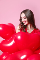 Valentine day. Beauty girl with red heart air balloon portrait on pink background. Birthday party,