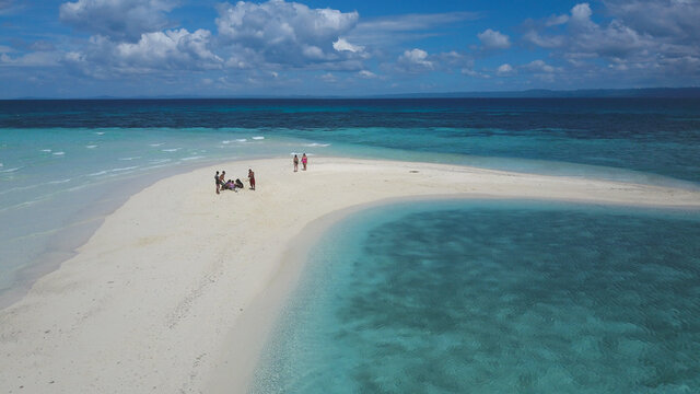 Aerial Of A Couple Of Tourists Frolicking At A White Sandbar In The Middle Of The Day. Shot In Bohol, Philippines. Tourism And Adventure Concept.