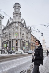 beautiful brunette girl on the street in St. Petersburg in winter. snowing