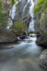 Waterfall in a tropical forest. Waterfalls in Kamphaeng Phet Province, Thailand. Vertical picture of the waterfall. Streams and rocks in the forest