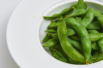 Hot Japanese Edamame Served on a white plate, appetizer menu