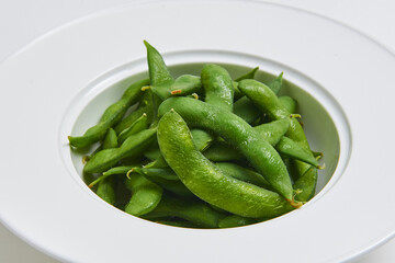 Hot Japanese Edamame Served on a white plate, appetizer menu