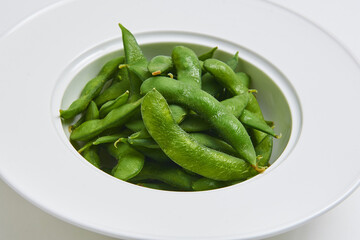 Hot Japanese Edamame Served on a white plate, appetizer menu